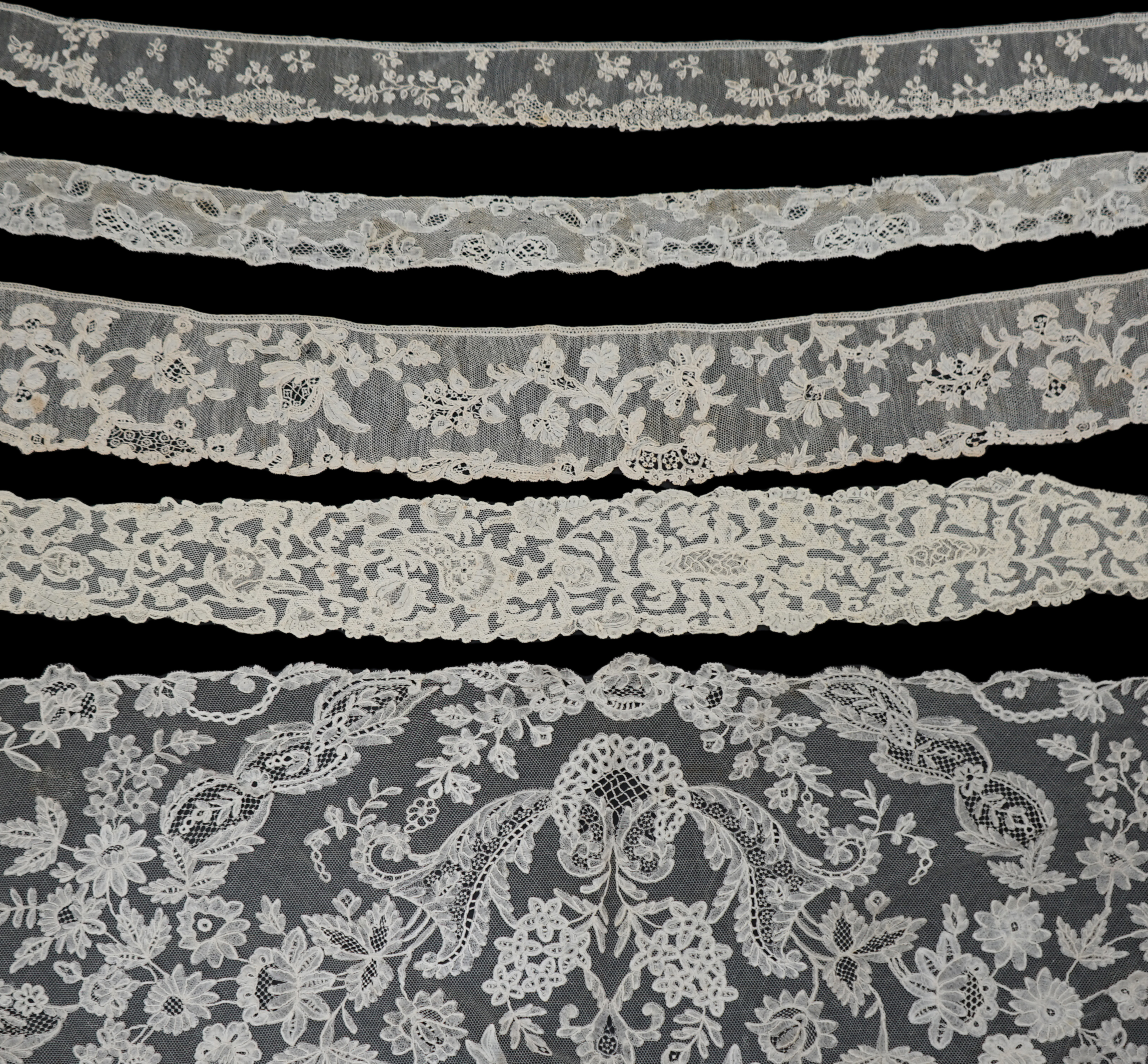 A large section of an ornate 19th century Brussels bobbin lace wedding veil, with two finished edges and one cut edge together with 18th century and later needle lace, an Argentan and an Alencon trimming, possibly an 18t